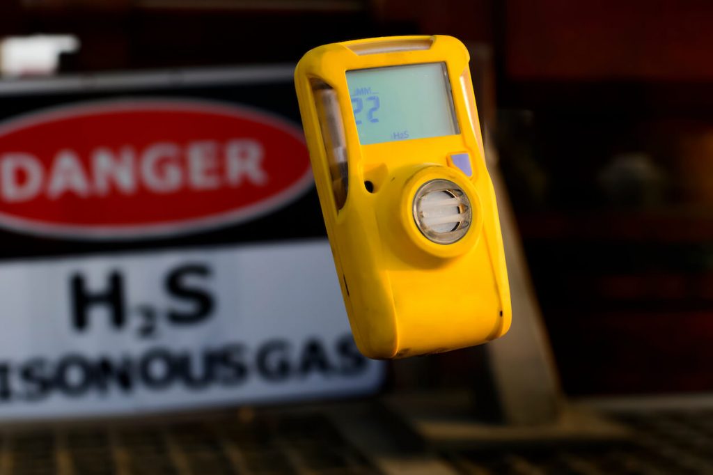 gas detection monitor in front of H2S sign
